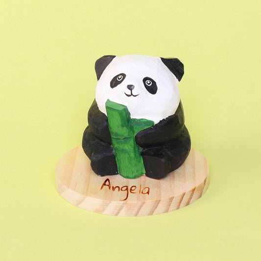 Panda figurine holding bamboo on a wooden base with 'Angela' engraved, against a light green background