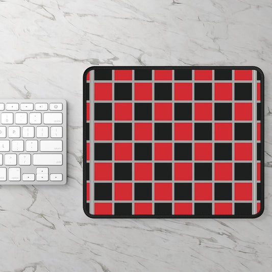 Checkered mouse pad with red and black squares on a marble surface with a keyboard.