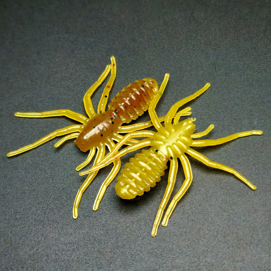 Two yellow spider-like fishing lures on a dark gray background