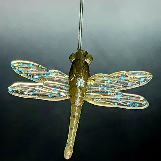 Decorative dragonfly fishing lure with beaded wings on a dark background