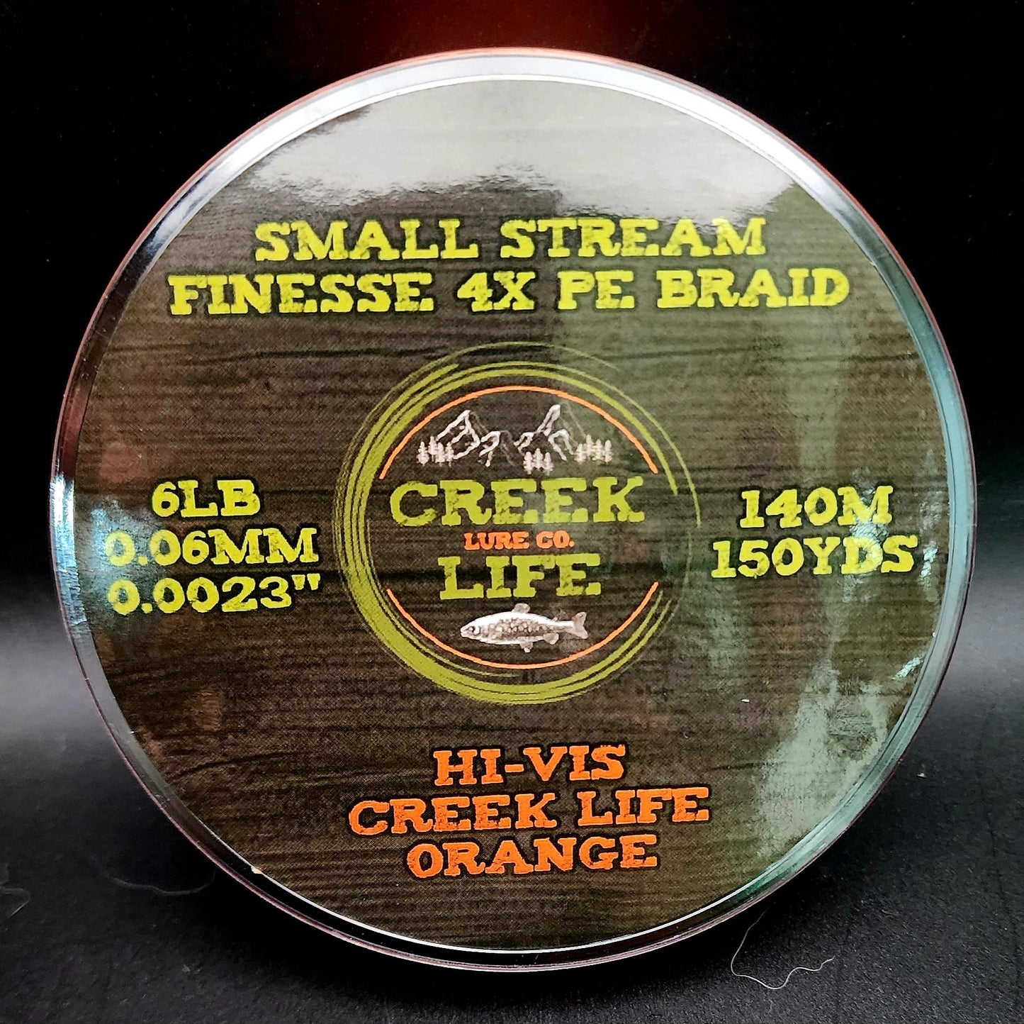 Fishing line spool with Creek Lure Co. branding on a dark background