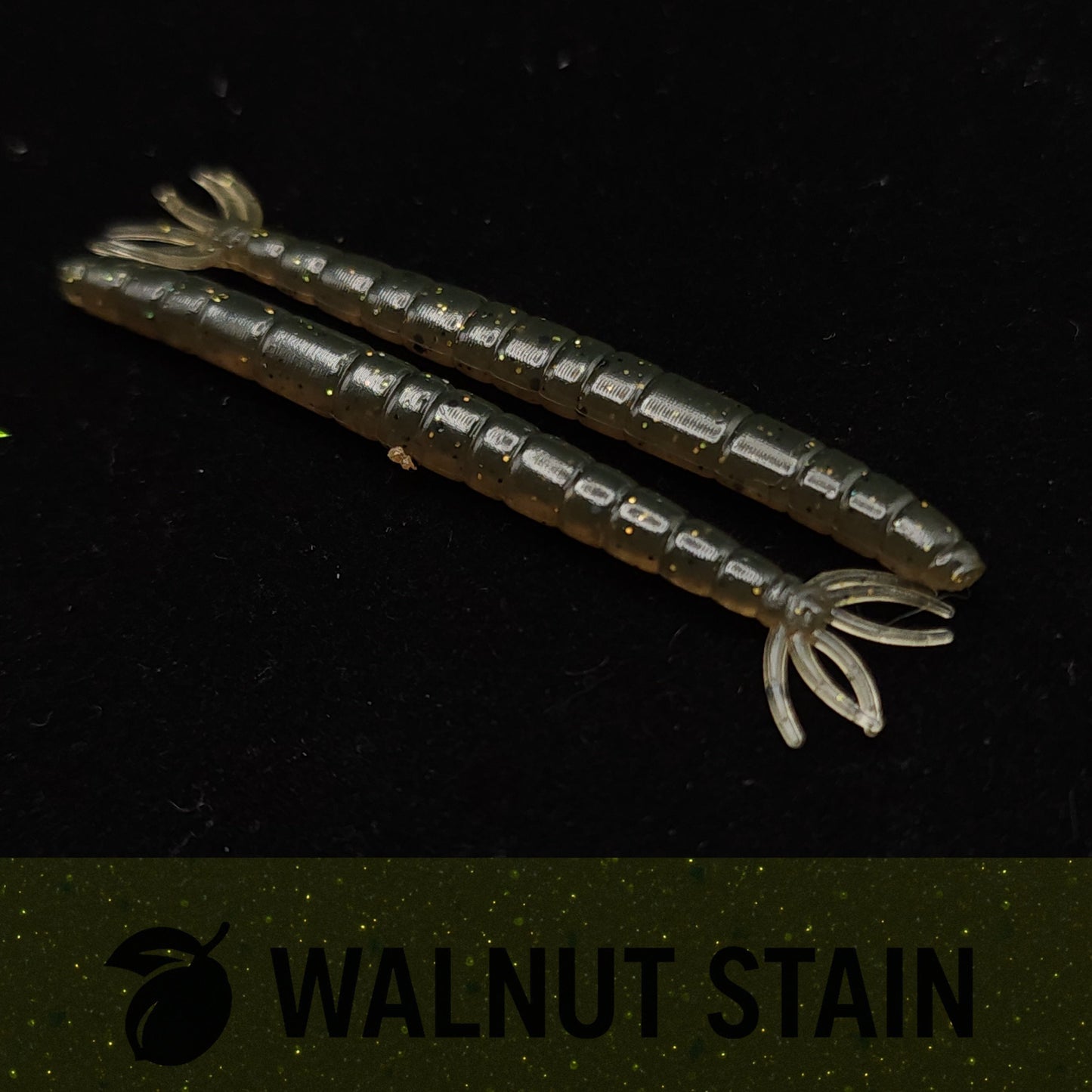 Two fishing lures with a walnut stain finish on a black background