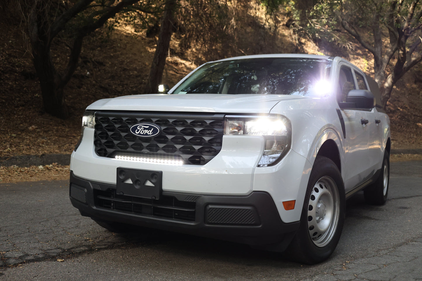 White Ford SUV parked on a road with light bar and fog lights on
