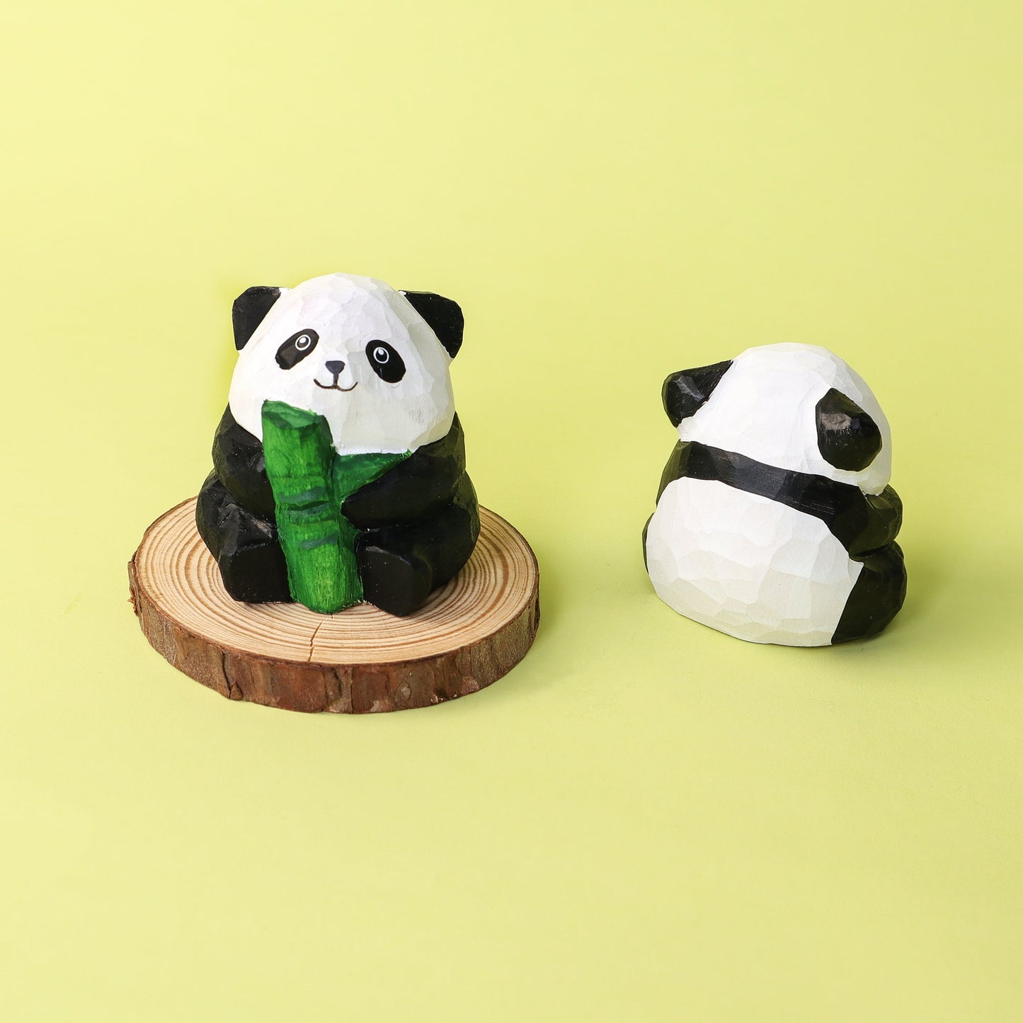 Two panda figurines on a yellow background