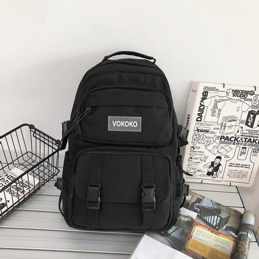 Black backpack with VOKOKO logo on a surface with magazines and a basket.