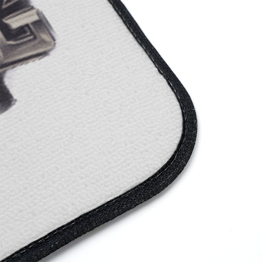 Close-up of a white textured floor mat with a black stitched border, showing part of a black and gray graphic print on a white background.