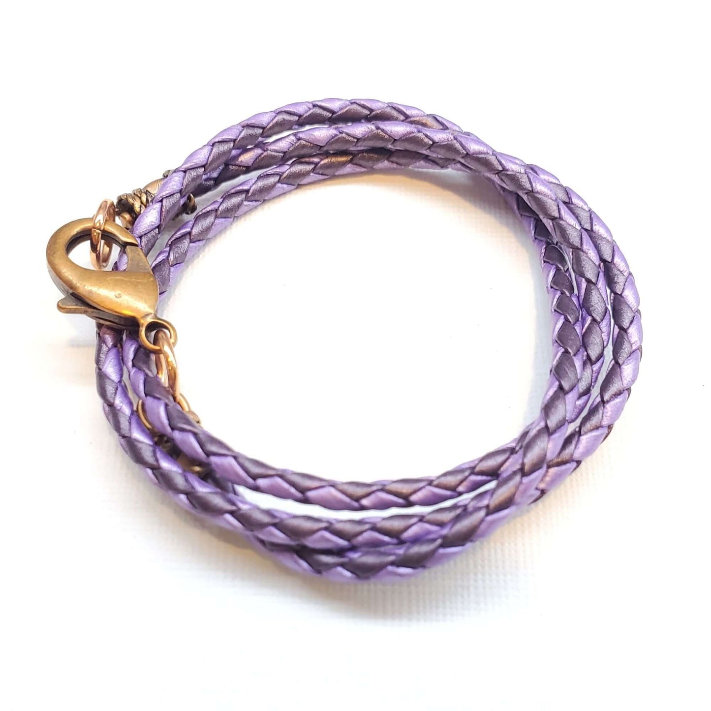 Purple braided leather necklace with a gold clasp on a white background
