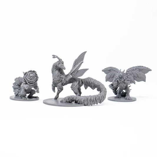 Three fantasy creature figurines on white stands against a white background