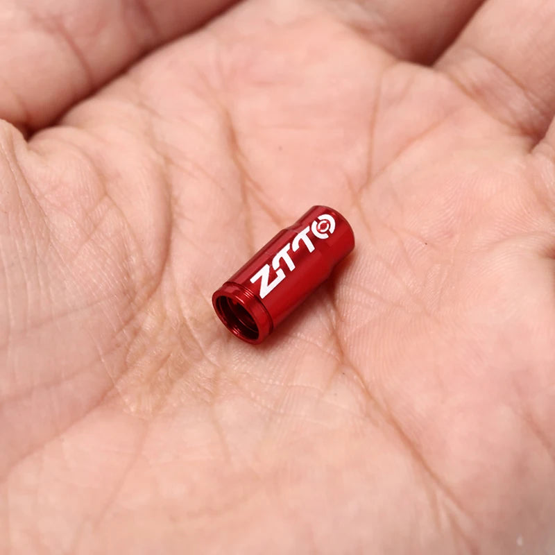Red ZTTO bicycle stem cap on a person's palm