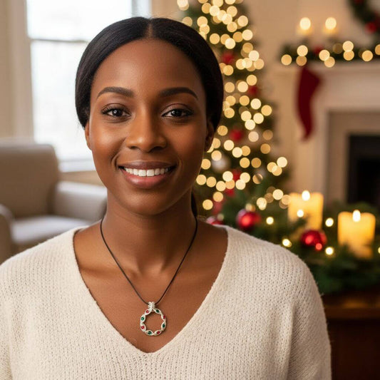 Woman wearing a necklace with a Christmas tree and fireplace in the background