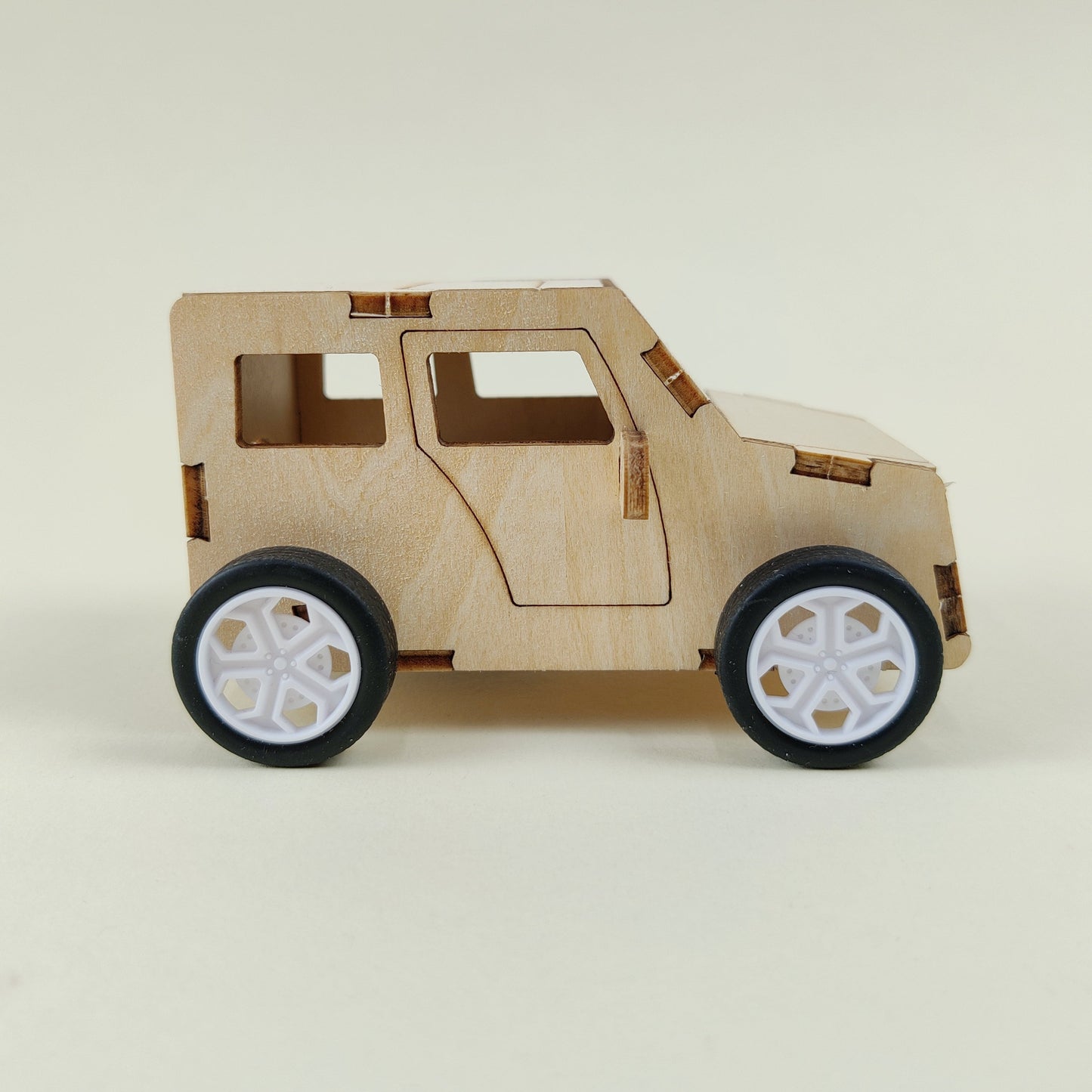 Wooden model of a car on a beige background