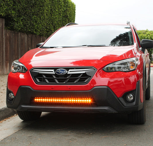Red Subaru SUV with additional LED lights on a street