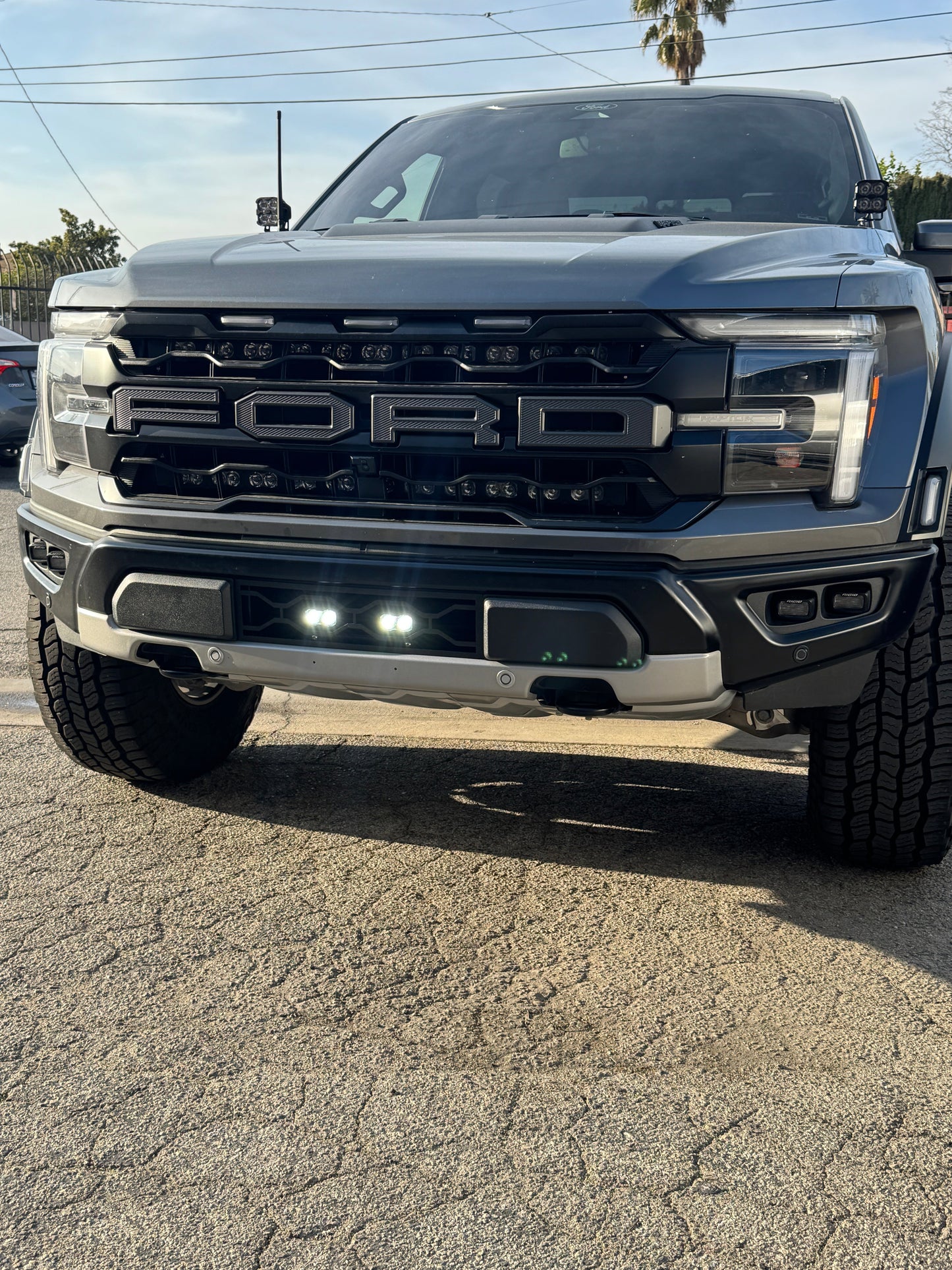 Front view of a Ford truck on a paved surface with a clear sky.