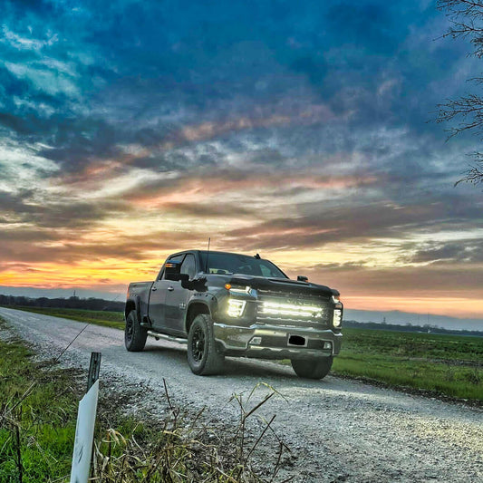 Silverado Truck on a rural road with a colorful sunset sky and LED Light Bars