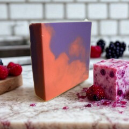 Colorful soap bars with berries on a marble surface