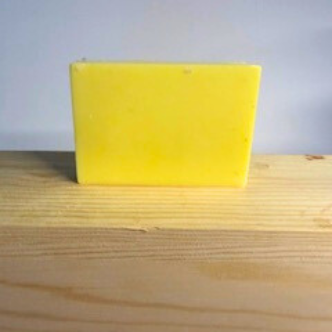 Lemon Zest- Lemon Scented Handmade Soap block on a wooden surface with a light gray background