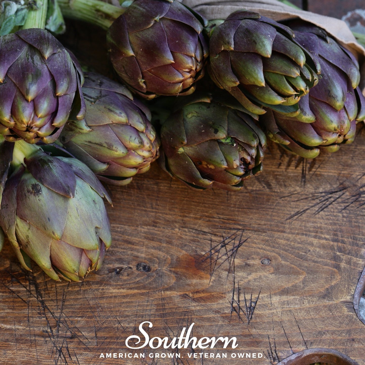 Artichokes on a wooden surface with 'Southern' branding.