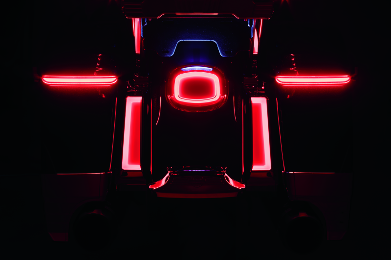 Back view of a vehicle with illuminated red taillights on a dark background