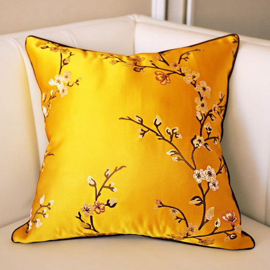 Yellow pillow with floral embroidery on a white couch