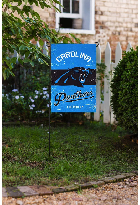 Carolina Panthers garden flag on a grassy lawn with a house in the background
