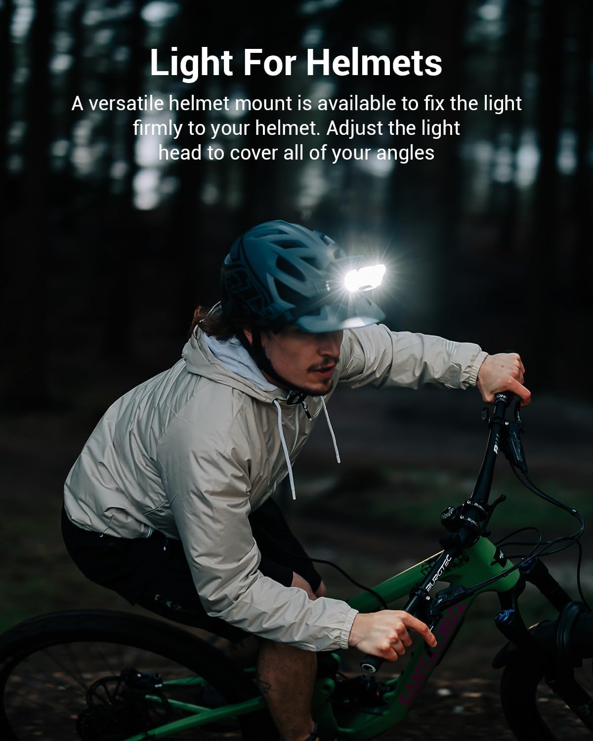Person riding a bike at night with a helmet light attached, in a dark forest setting.