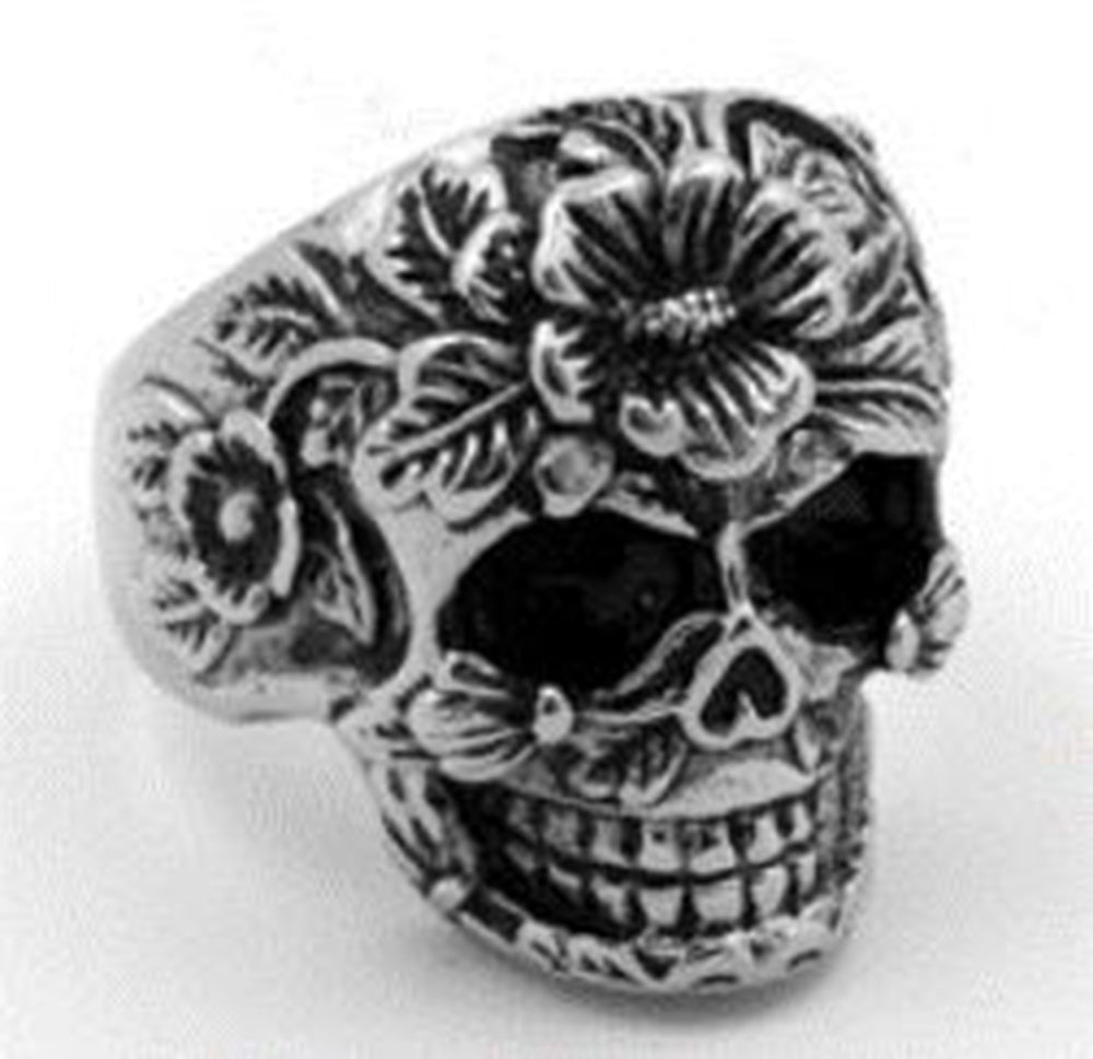 A stainless steel ring with a detailed flower face skull design.