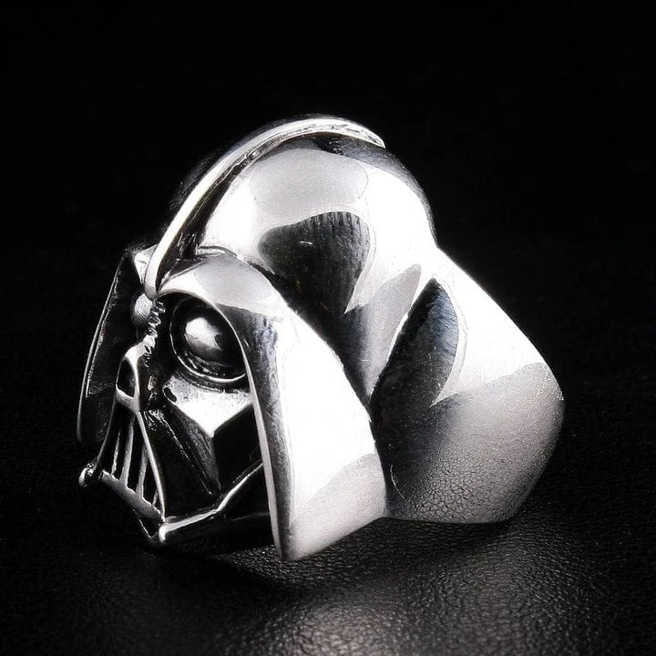 Silver Darth Vader helmet ring on a dark background