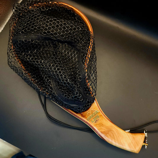 Fishing net with wooden handle on a dark surface