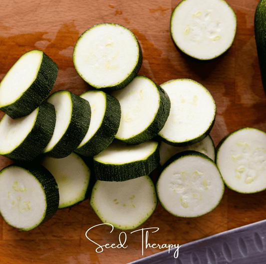 Sliced zucchinis on a wooden cutting board with 'Seed Therapy' branding.
