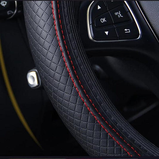 Close-up of a car steering wheel with red stitching and control buttons.