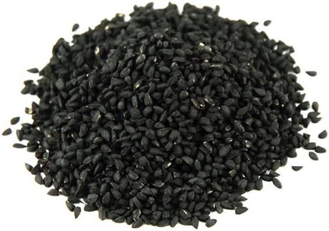 Pile of black onion seeds on a white background