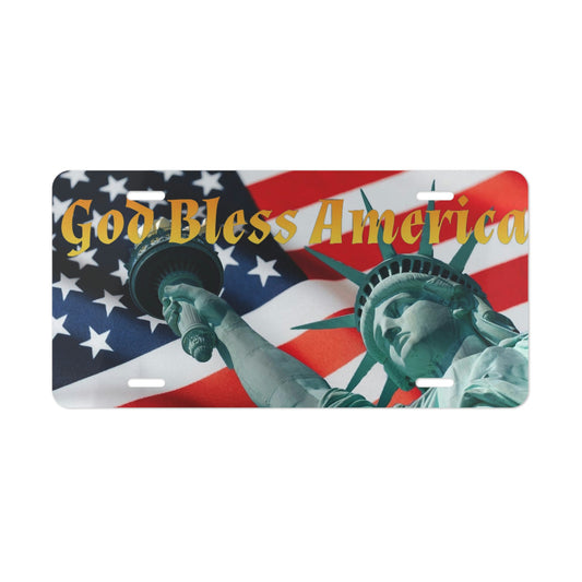 A vanity plate featuring the Statue of Liberty with an American flag background and the text 'God Bless America' in gold.