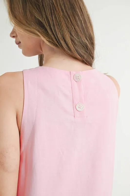 Pink sleeveless top worn by a woman on a white background