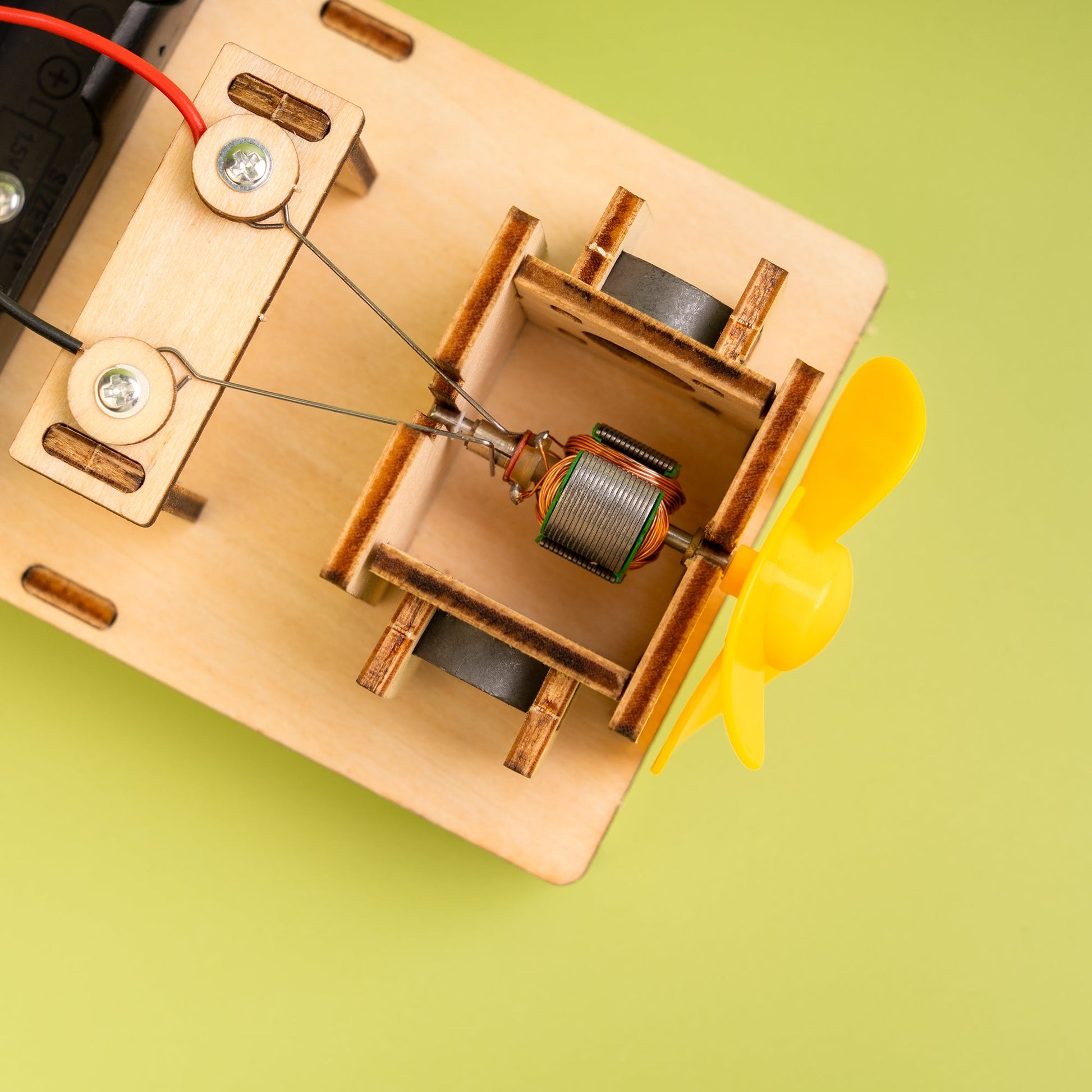 Close-up of a mechanical device with a yellow propeller on a green background