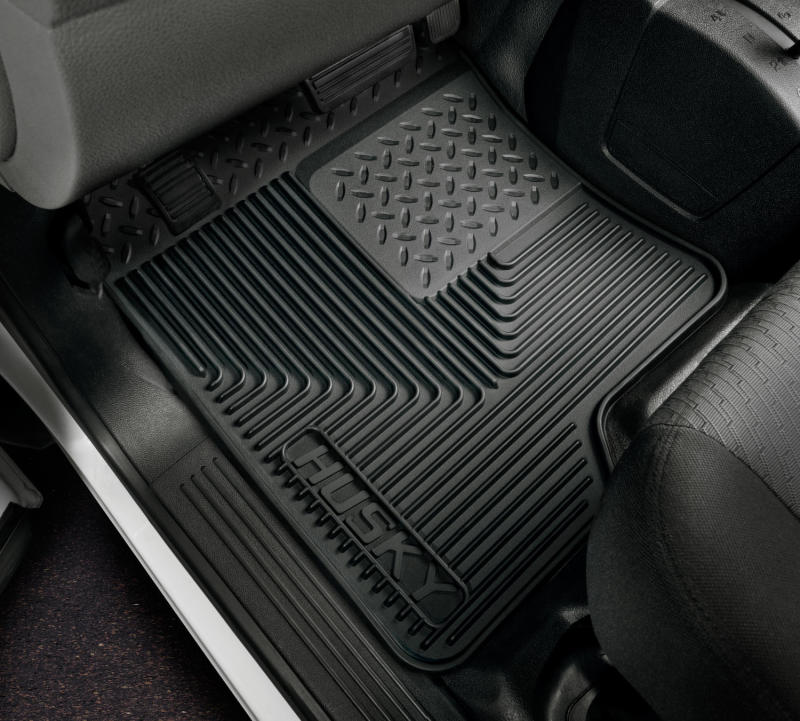 Black car floor mats with a visible brand logo on a vehicle interior.