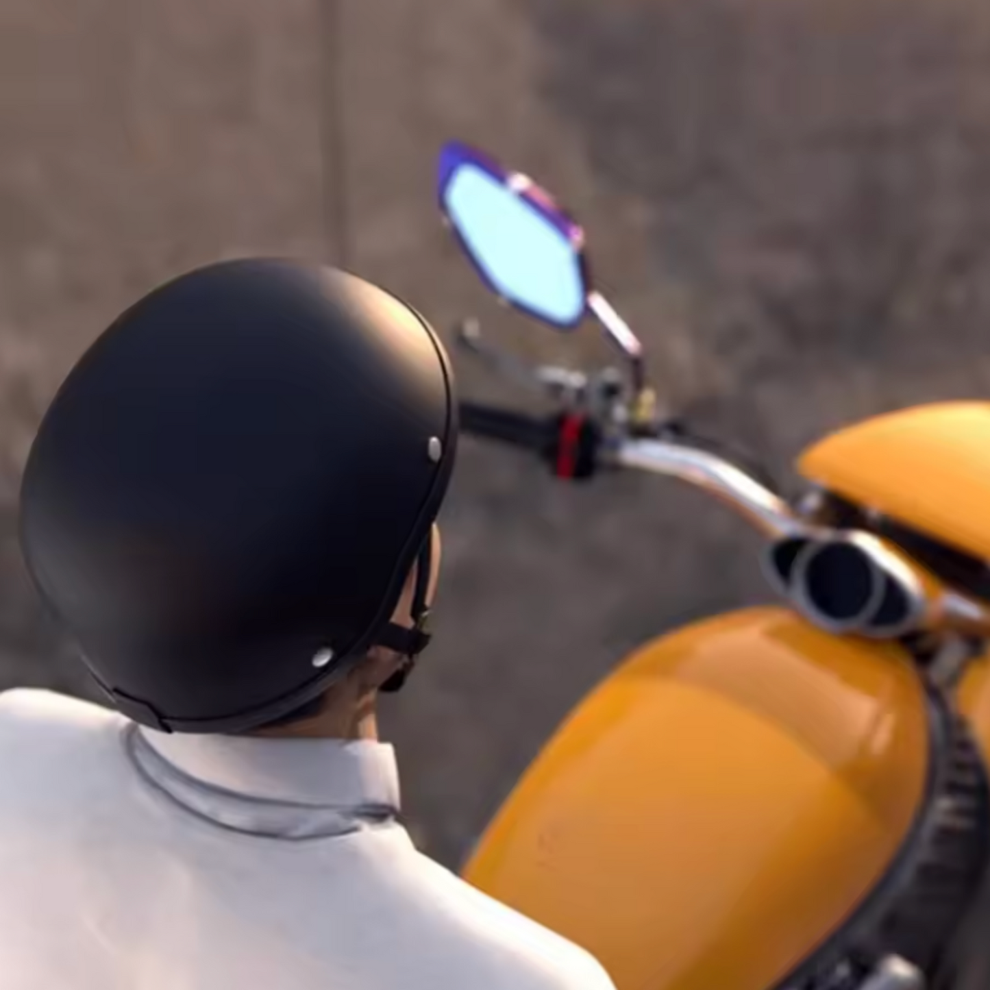 Person wearing a black helmet sitting on a yellow motorcycle with a blurred background