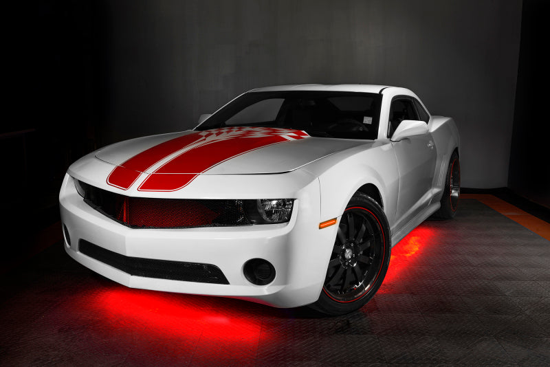 White sports car with red stripes on a dark background with underbody lighting