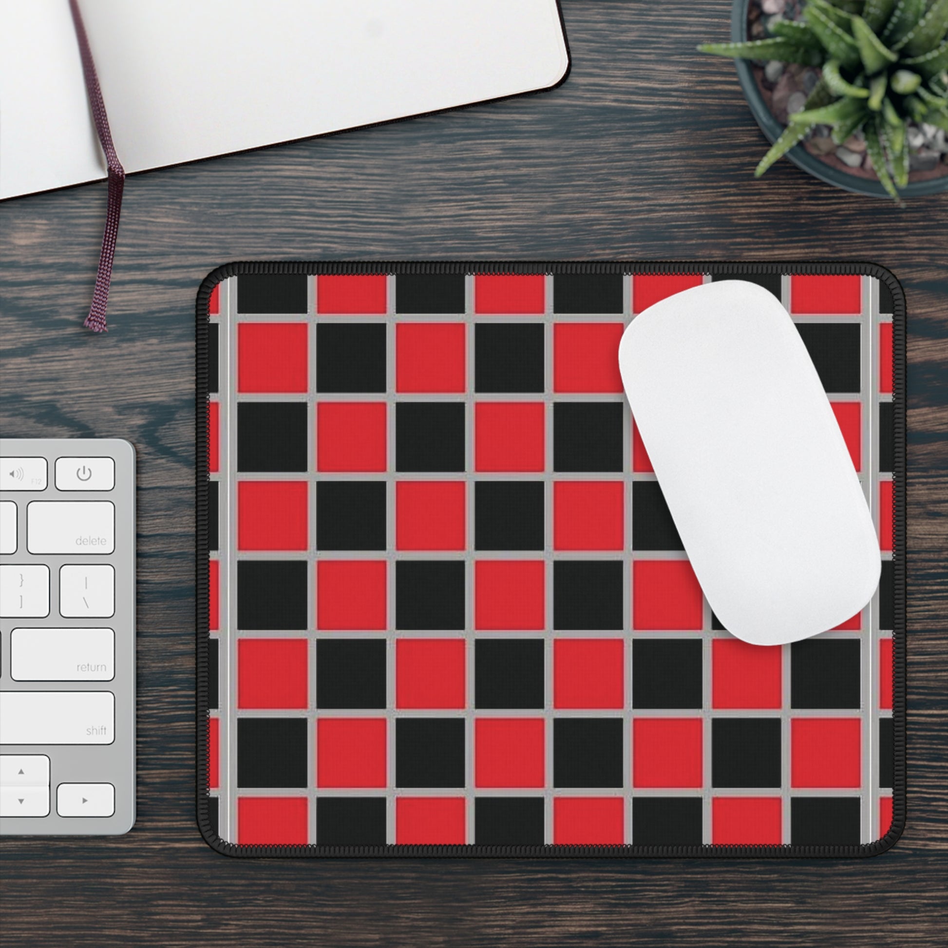 Red and black checkered mouse pad with a white mouse on a wooden desk.