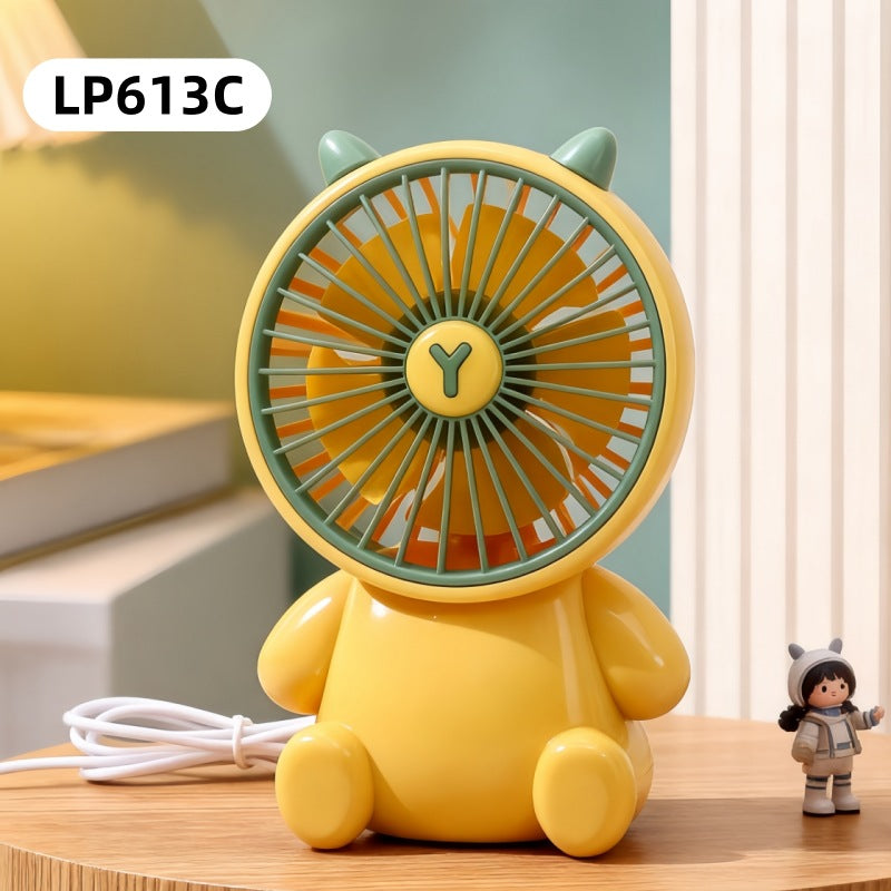 Yellow cartoon-like fan on a wooden surface with a blurred background