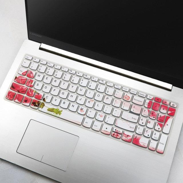Laptop with a floral keyboard cover on a light gray surface