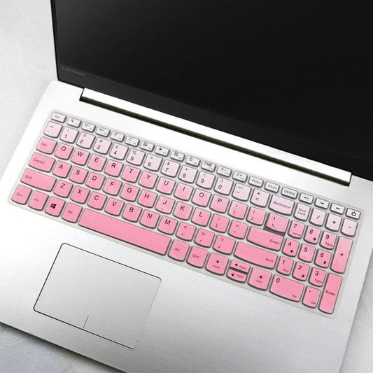 Laptop with a pink keyboard cover on a light gray surface