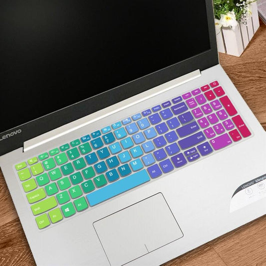 Laptop with a colorful keyboard cover on a wooden surface