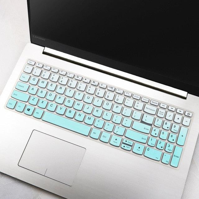 Laptop with a turquoise keyboard cover on a light gray surface