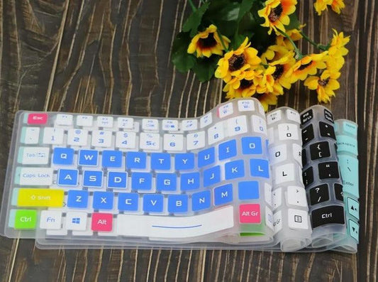 Keyboard cover with colorful keys on a wooden surface with flowers