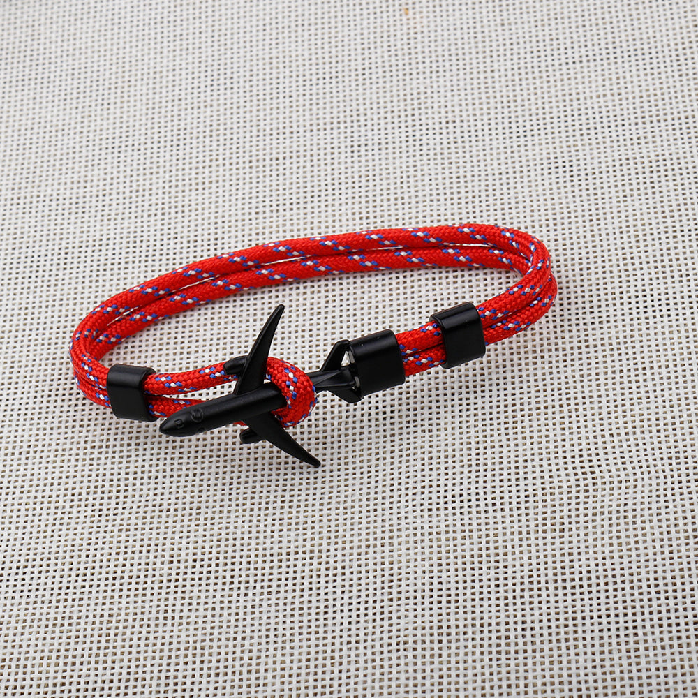 Red and blue braided bracelet with black clasp on a textured gray background