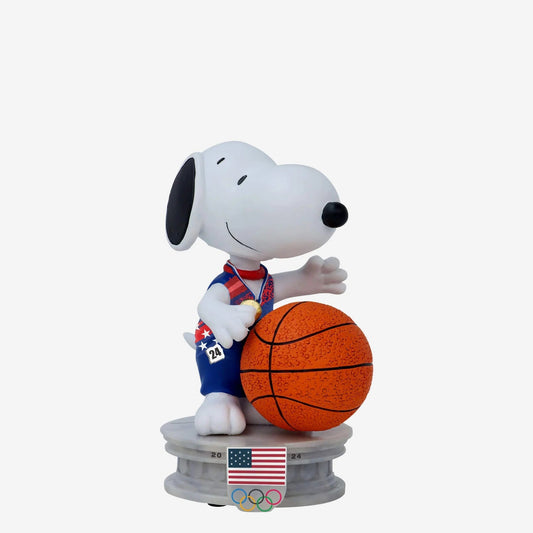 Snoopy figurine holding a basketball with an American flag and Olympic rings on a white background