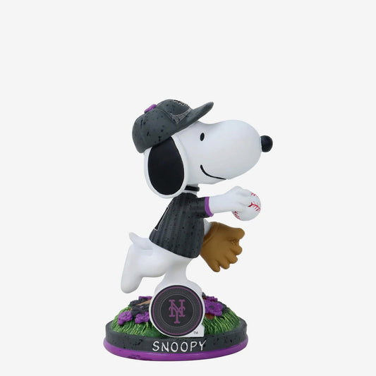 Snoopy figurine in a Yankees baseball uniform with a cap and glove on a white background