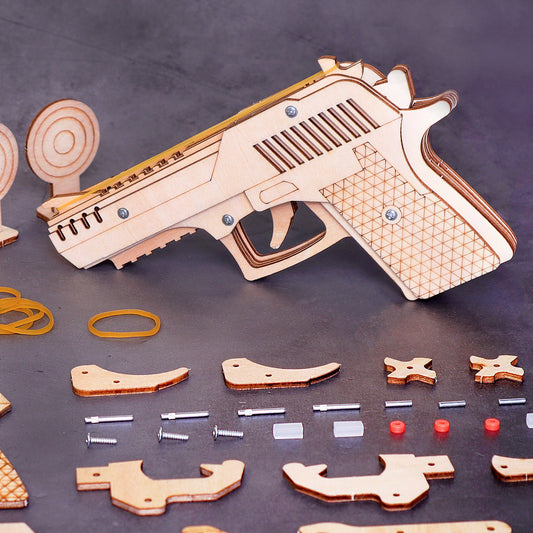 Wooden gun model kit with scattered pieces on a dark surface