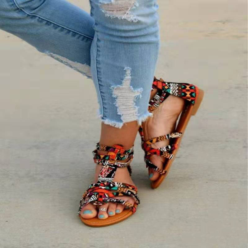 Colorful sandals worn with ripped jeans on a neutral background