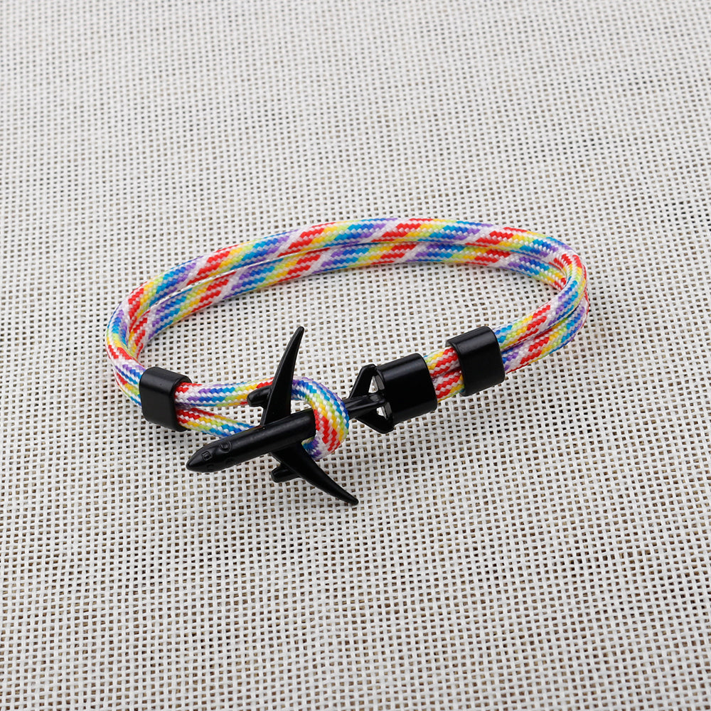 Colorful braided bracelet with a black clasp on a textured gray background
